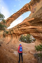 Hiker in front of Double O Arch