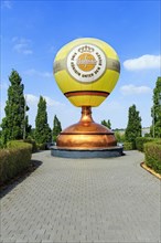 Hot air balloon on sculpture of a brewing kettle