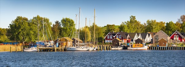 Boat docks with sailing boats and holiday homes in the harbour of Gager
