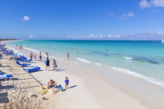 Tourists on the sandy beach with turquoise water