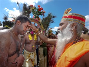 Priest blessing Kavadi dancer with pierced cheek