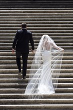 Bride and groom walking up a staircase