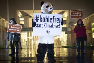 Demonstrator disguised as a panda bear with sign Coal-free instead of climate crisis in protests for a quick exit from coal energy and for compliance with climate protection goals in front of the Fede...