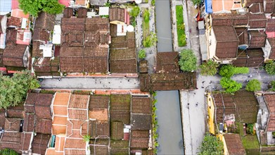 Roofs of old houses with Japanese Covered Bridge or Cau Chua Pagoda in Hoi An ancient town