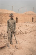 Worker with shovel in a brickyard