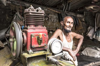 Portrait of a worker in front of an engine
