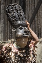 Dancer in traditional clothing wearing carved mask