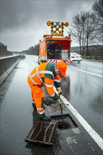 Workers cleaning the gully on the A4 motorway