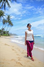 Young woman walking on the beach between Weligama and Ahangama