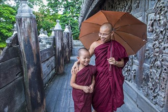 Young and elder Monks with umbrella at Shwenandaw Monastery