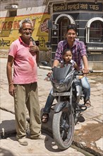 Man and child on motorcycle with older man