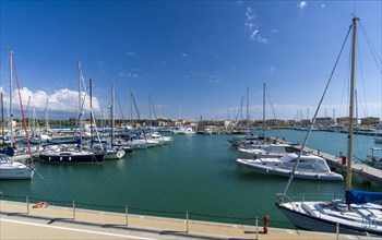 Sailing and motor boats are anchored in the harbour