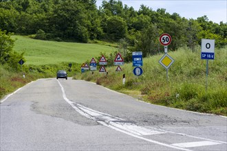 Road flanked bei many traffic signs