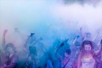 Thousands of young women and man are throwing color powder in the air at the colorful Holi festival