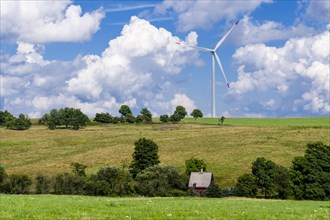 Wind power plant and a little house in agricultural landscape