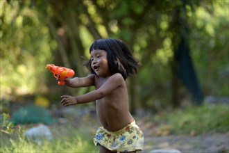 Indigenous playing with a plastic gun