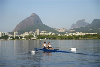 Two young women participating in early morning rowing training in the Lagoa Rodrigo de Freitas Lagoon