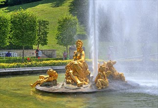Golden sculpture group with fountain in the basin of the garden parterre