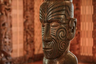 Traditional carving of a Maori statue in the assembly hall Te Whare Runanga