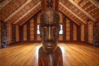 Traditional carving of a Maori statue in the assembly hall Te Whare Runanga