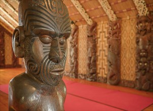 Traditional carving of a Maori statue in the assembly hall Te Whare Runanga