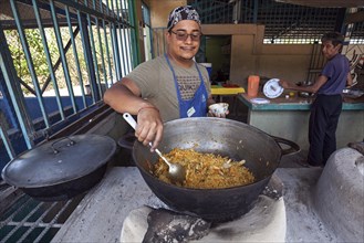 Local man preparing rice dish over open fire