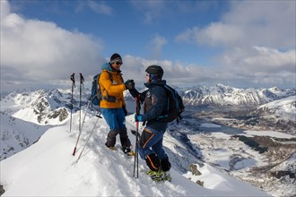 Mountaineers congratulate themselves at the summit of Stortinden in winter
