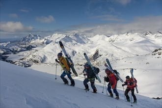 Mountain guide leads a rope team of ski mountaineers on Blatinden
