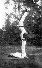 Two acrobats training on the meadow