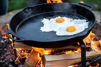 Fried eggs in a pan over an open fire