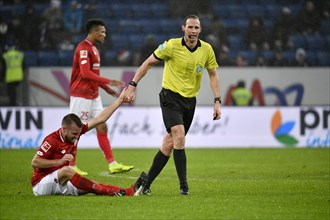 Referee Sascha Stegemann helps Daniel Brosinski 1st FSV Mainz 05 on his feet