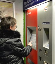 Older woman buys ticket at ticket machine