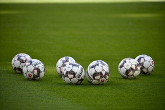 Seven match balls adidas Derbystar lying on grass