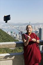 Buddhist monk takes a selfie with selfie stick