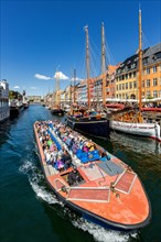 Many people in tourist boat in Nyhavn Canal