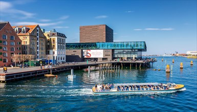 A canal tour boat in front of the Royal Danish Playhouse