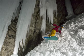 Snowboarder in front of icicles