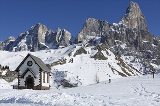 Chapel at the mountain pass Passo Rolle with snow