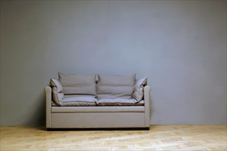 Lonely couch in front of a wall in the room