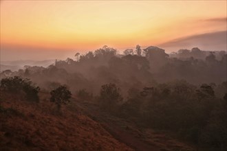 Sunrise with morning haze over wooded hills