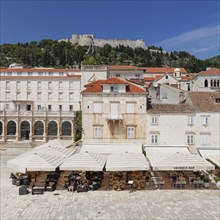 Street cafes at Trg Svetog Stjepana with view to the fortress