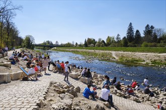 People enjoy beautiful weather at the river Wertach