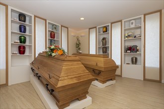 Coffins and urns in the exhibition room of a funeral parlour