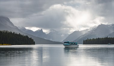 Excursion boat with tourists on Maligne Lake