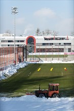 Snowplough clears snow at the football pitch