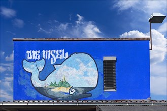 Graffiti whale figure on a building container