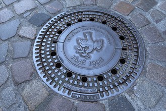 Manhole cover with the motive of a dove of peace