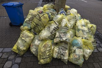 Stacked yellow sacks for waste disposal in the pedestrian zone