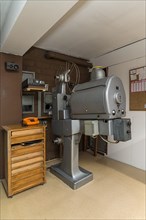 Cinema projector by Zeiss Ikon around 1950 with film spool cabinet in a cinema projection room