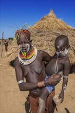 Woman with child of the tribe of the Karo with face painting and necklace